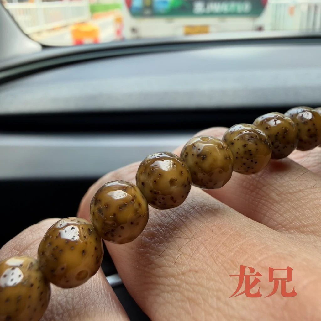 九个月后的星月菩提特写：珠面光滑莹润，黑色星点清晰，珠间有轻微色差
