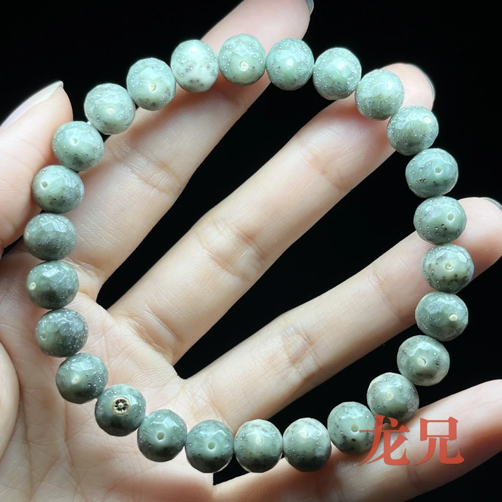 刚入手的星月菩提实拍：底色青灰绿，珠面中央可见月眼，四周密布细星